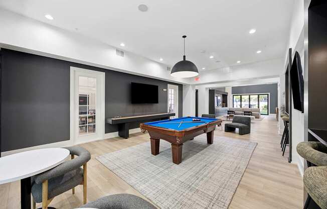 A room with a pool table and a television.