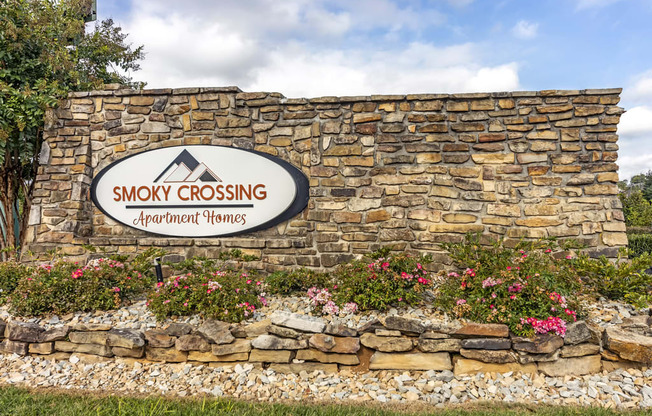 a stone wall with a sign that reads smoky crossing apartment homes