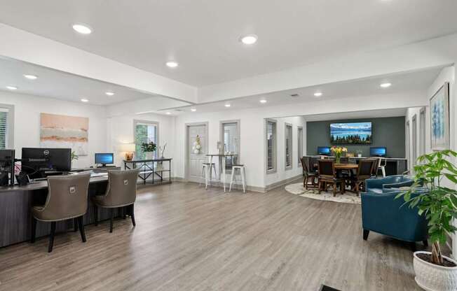 A modern leasing office with a wood floor and desks and chairs at Gwinnett Square Apartments in Duluth, GA