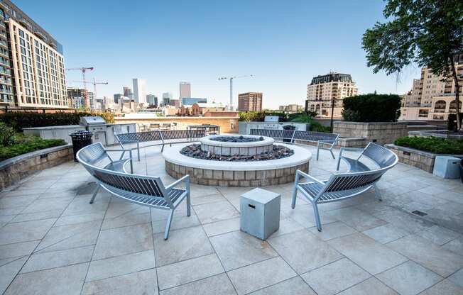 an outdoor terrace with a firepit and a view of the city
