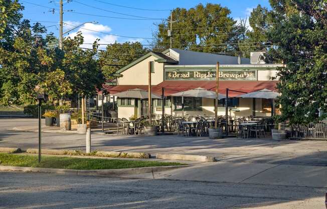 the outside of a restaurant with tables and umbrellas