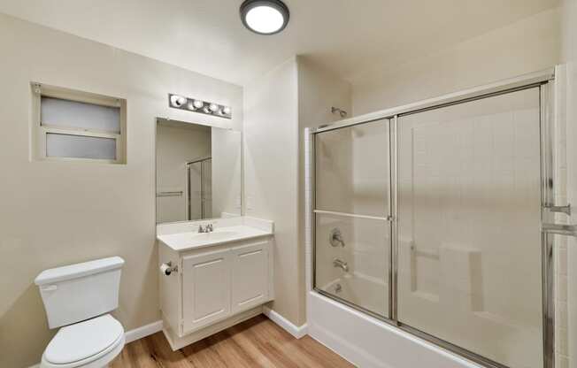 an empty bathroom with a shower toilet and sink