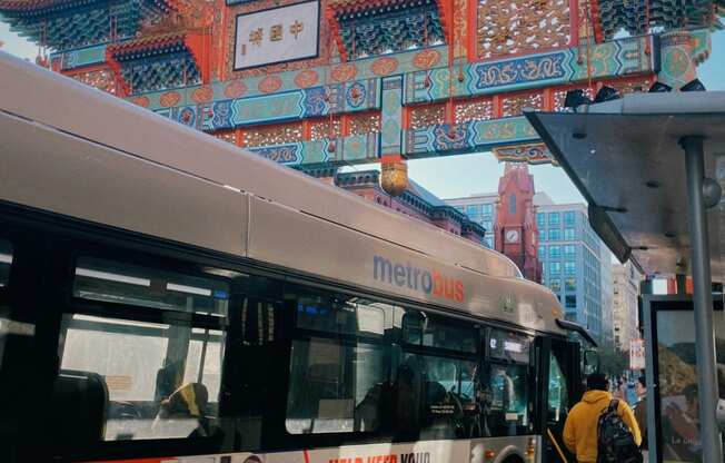 a bus is parked at a bus stop in front of a pagoda