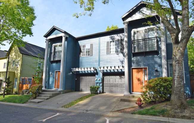 A blue two-story house with a balcony on the second floor.