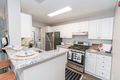 a kitchen with white cabinets and stainless steel appliances at Merion Milford Apartment Homes, Milford, CT