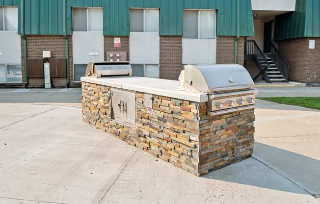 an outdoor grill with a building in the background