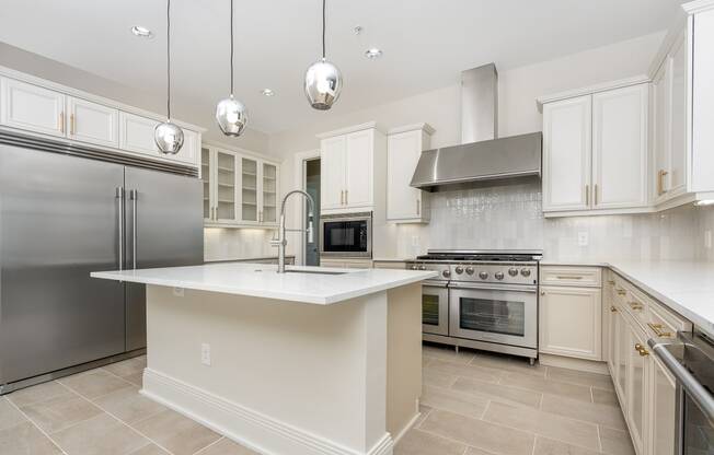 a large white kitchen with stainless steel appliances