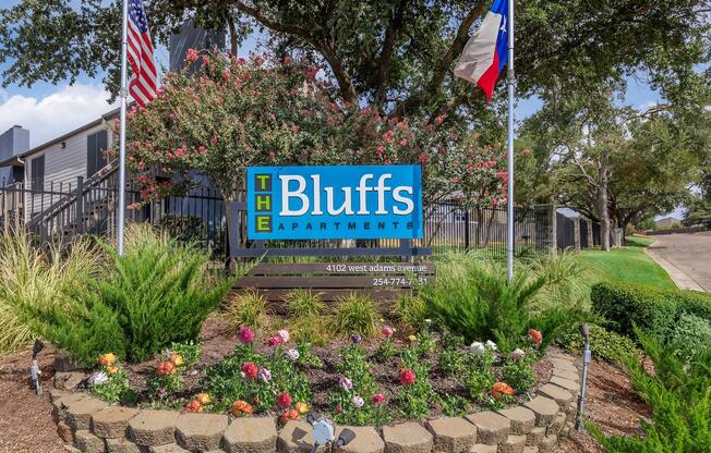 a close up of a flower garden in front of a sign