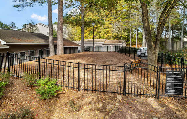 A black fence surrounds a yard with a house in the background.