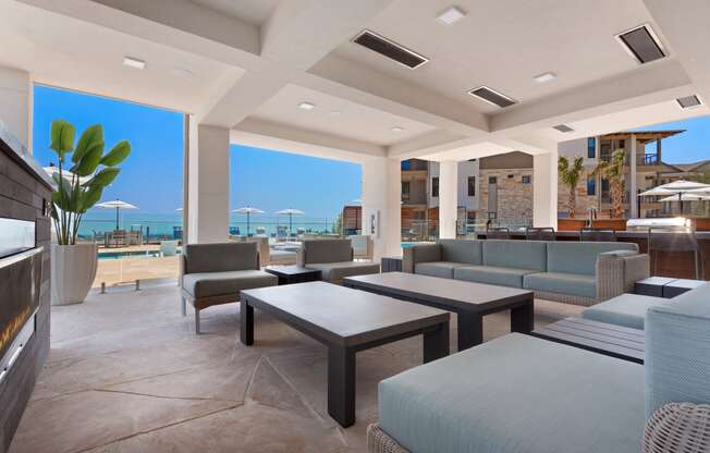 a living room with couches and tables and a view of the ocean