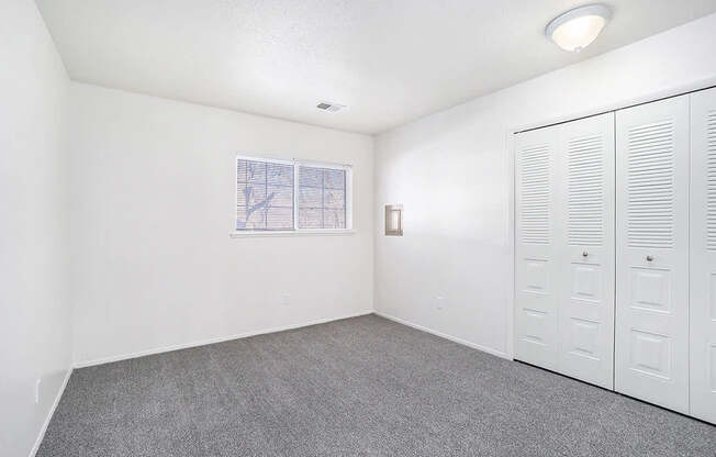 A room with white walls, a window, and a row of white lockers.