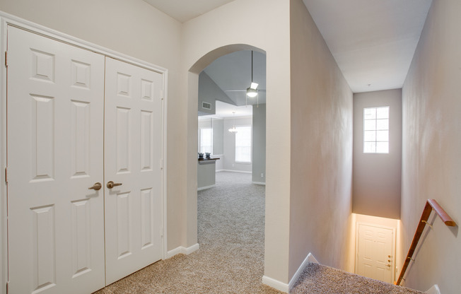 View of Hallway with Stairway, Carpet, and View of Living Room at Raveneaux Apartments