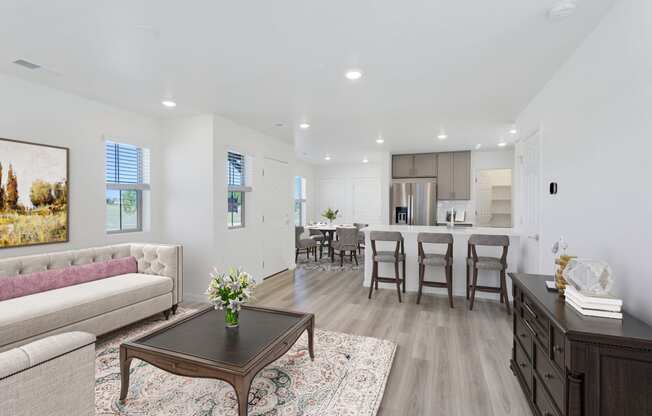 a living room with a couch and a coffee table in front of a kitchen