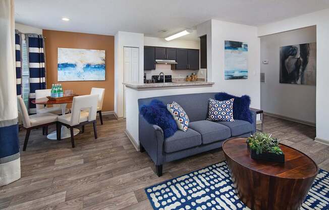 A living room with a blue couch and a wooden coffee table.