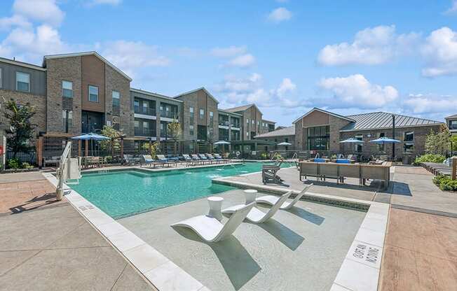 Community Swimming Pool with Pool Furniture at Alta 3Eighty Apartments located in Aubrey, TX.