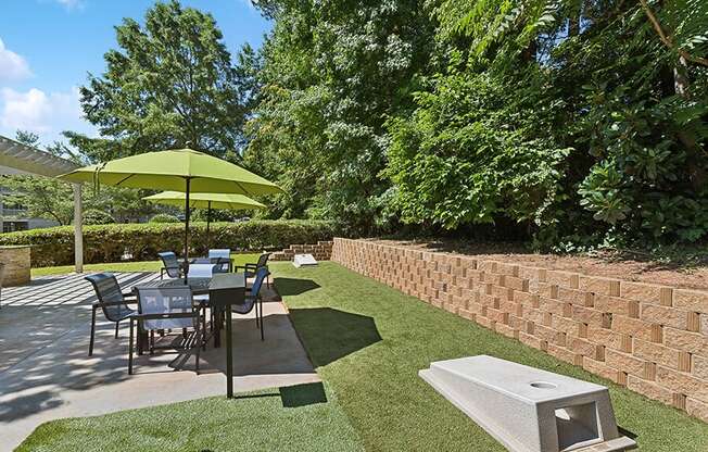 Outdoor Picnic Area with Lounge Furniture and Corn Hole Sets at Retreat at Stonecrest Apartments located in Lithonia, GA.