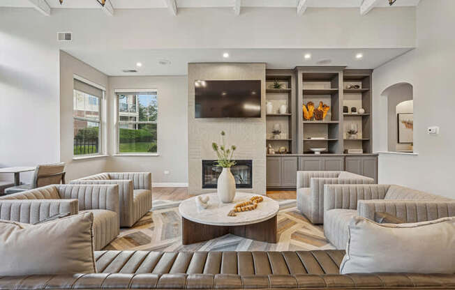 A modern living room with a fireplace and grey couches.