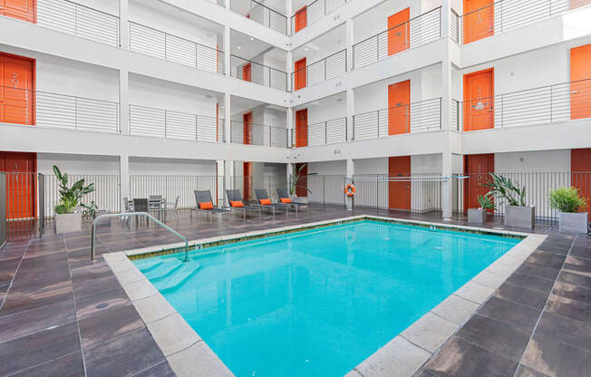 the pool of a hotel with chairs and a swimming pool