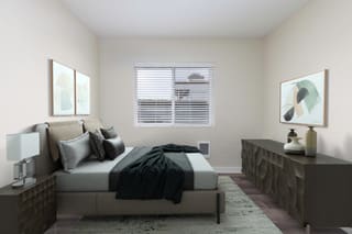 a bedroom with a bed and a dresser and a window