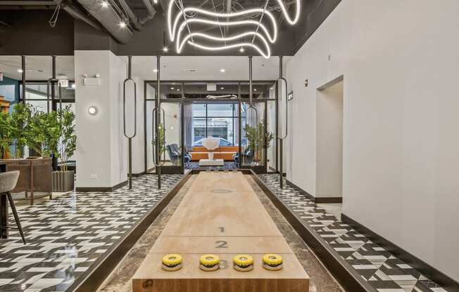 a bowling alley in the lobby of a building with a neon sign above it