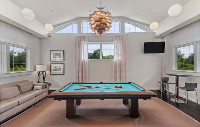 a living room with a pool table and a large window