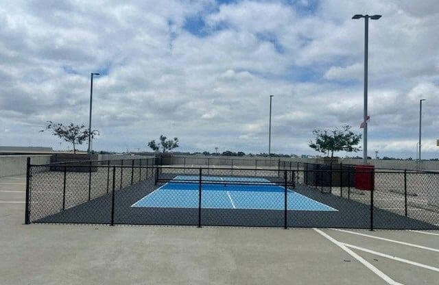 a rooftop pickleball court with a fence around it