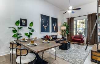 A dining room with a table set for two and a red chair.