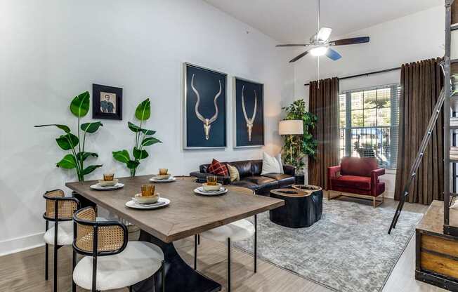 A dining room with a table set for two and a red chair.