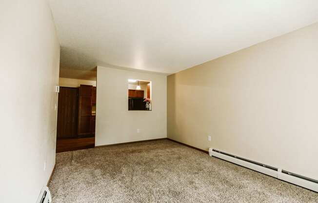 Grand Forks, ND Grandview II Apartments. A living room with baseboard heaters and a dining room in the background