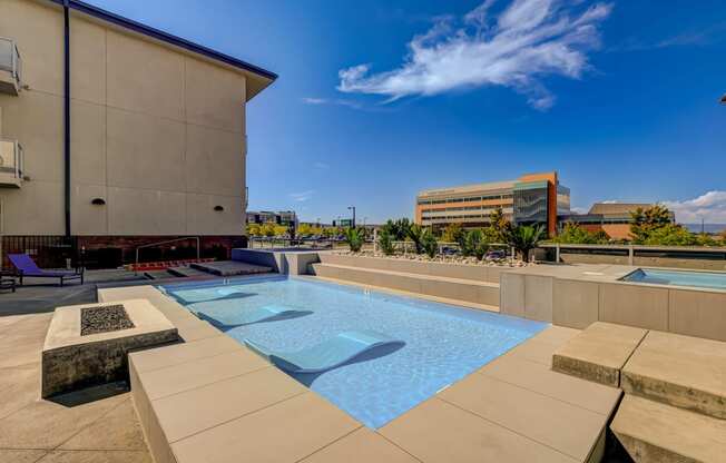 a pool on the rooftop of a building with a city in the background