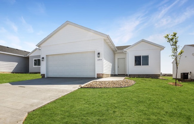 a white house with a driveway and a garage door