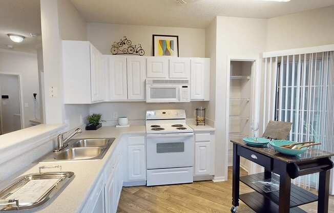 apartment kitchen with white cabinets and a sink