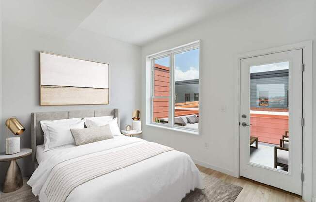 Compact bedroom with a comfortable bed with navy and white bedding, plush pillows, a white fluffy rug, and a plant by the window, creating a serene and inviting atmosphere.