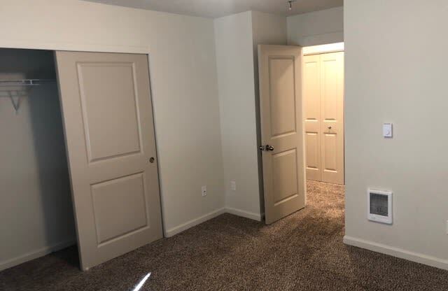 a bedroom with two doors and a closet