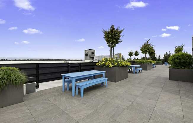 Rooftop Resident Lounge with a table and benches at Arabella Apartment Homes, Shoreline, WA