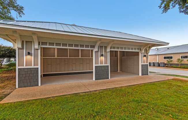 a house with two garage doors and a lawn at Crossgates Apartment Homes, Starkville