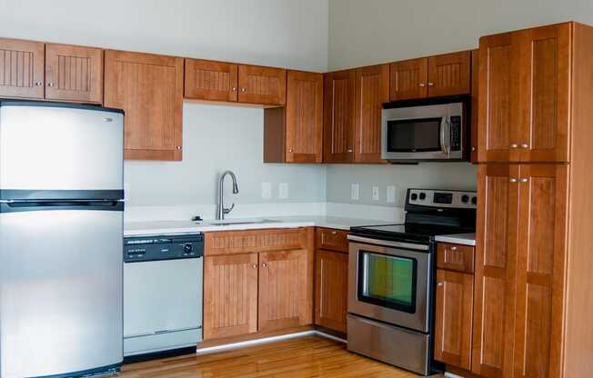 an empty kitchen with wooden cabinets and stainless steel appliances