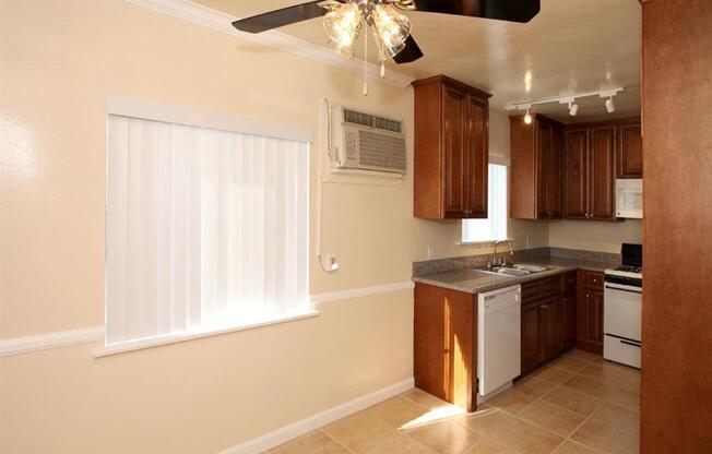 common living area with ceiling fan and kitchen