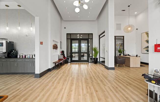 A modern office lobby with a wooden floor and white walls.