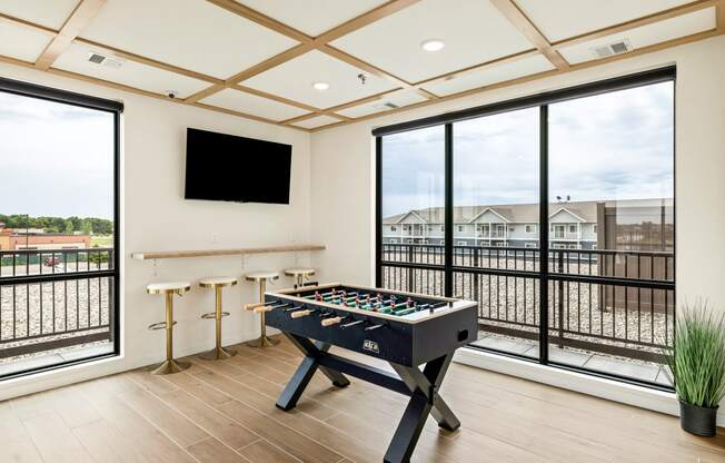 a game room with a foosball table and a large window at The Standard on 32nd, West Fargo, 58078