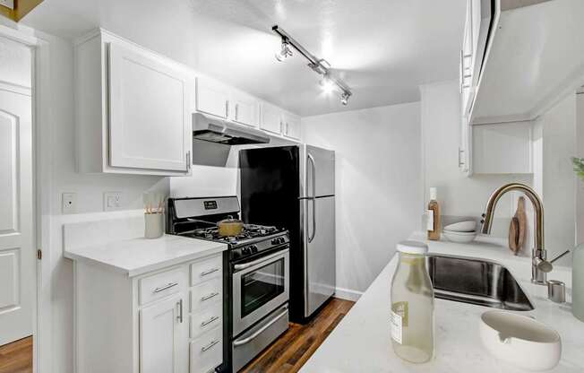 A white kitchen with a black stove and a black refrigerator.