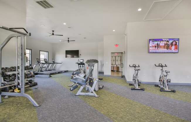 a gym with weights and cardio equipment and a tv at Sladestone Shadow Creek, Pearland, TX