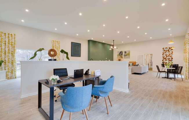 a desk with two chairs and a laptop in a room with a green chalkboard and a at Station JTown, Louisville Kentucky