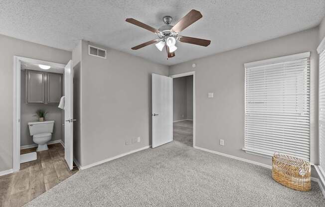 A room with a ceiling fan and a carpeted floor.