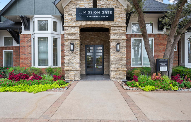 the entrance to mission gate residential building with a blue sign on top of the door at Mission Gate, Texas