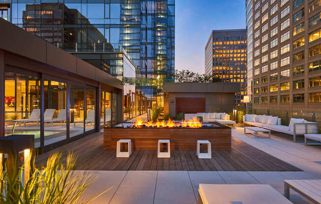 A modern outdoor seating area with a fire pit in the center.