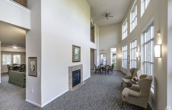 A spacious living room with a fireplace and a ceiling fan.
