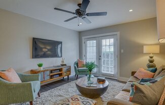 a living room with furniture and a ceiling fan