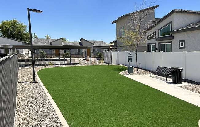 a backyard with a green lawn and a fence
