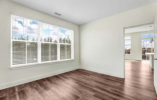 A room with a window and wooden flooring.